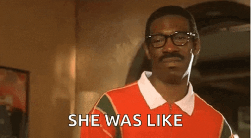 a man with glasses and a mustache is wearing a red shirt that says she was like .