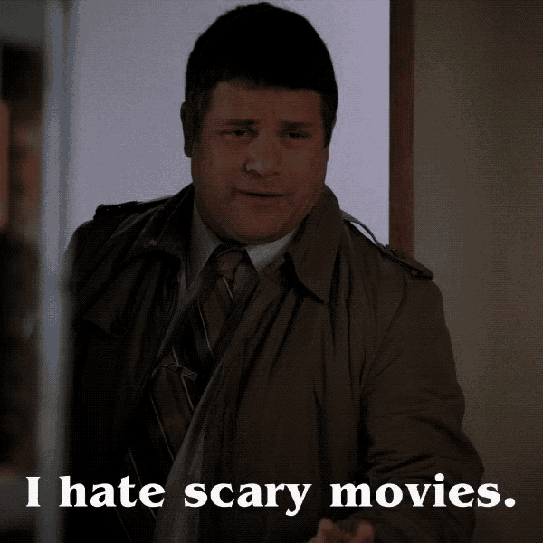 a man in a trench coat and tie says that he hates scary movies