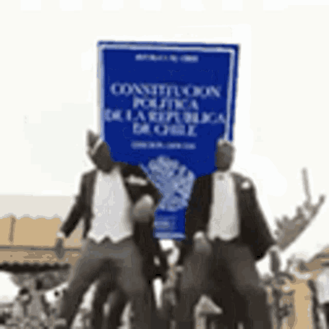 a group of men are standing next to each other holding a sign that says constitucion politica de la republica de chile .