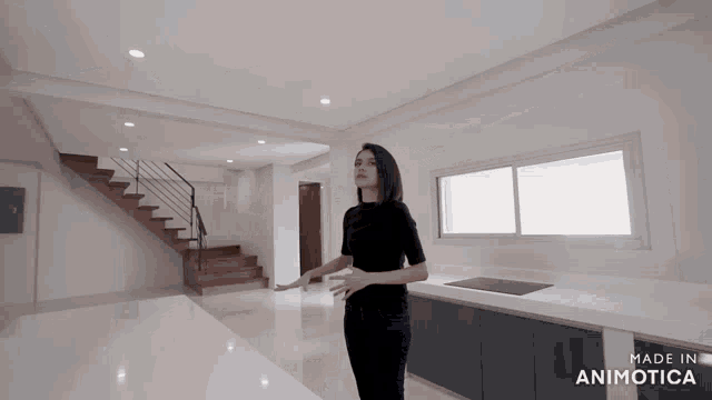 a woman stands in a kitchen with the words made in animatica on the bottom right