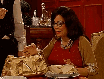 a woman is sitting at a table with a tva logo on her sleeve
