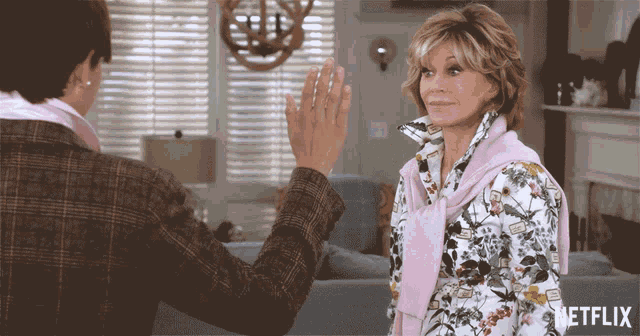 a man giving a woman a high five with a netflix logo on the bottom