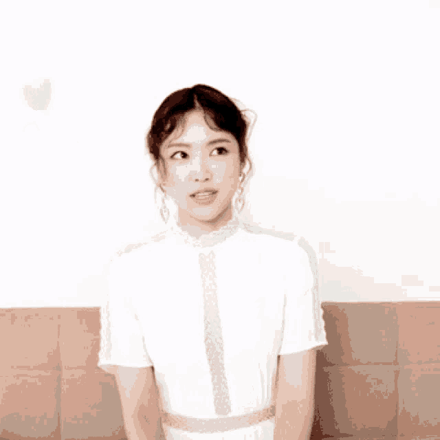 a girl in a white dress is sitting on a couch