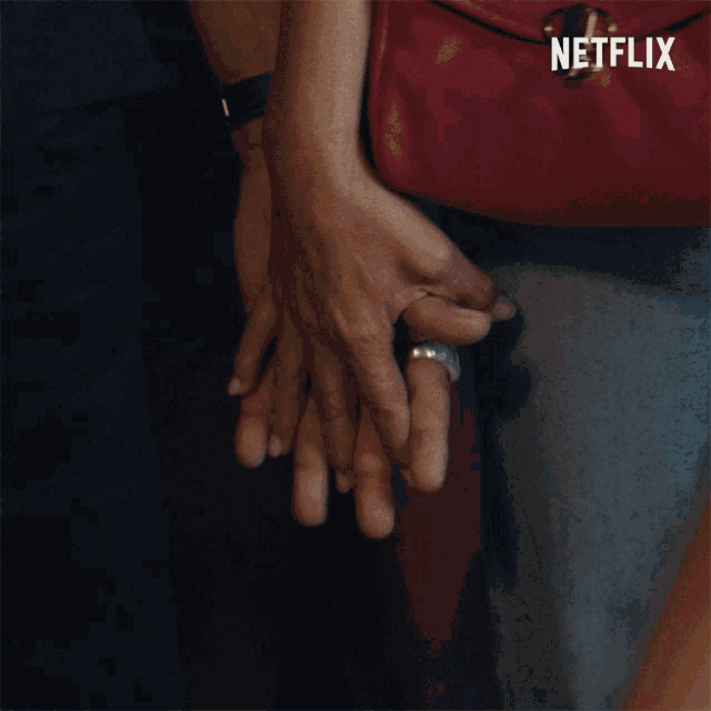 a person holding another person 's hand with a netflix logo in the background