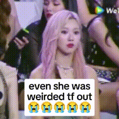 a woman with pink hair is sitting in front of a sign that says even she was weirded tf out ..