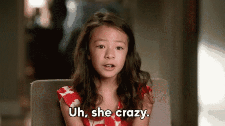 a little girl is sitting in a chair and saying `` uh , she crazy . ''
