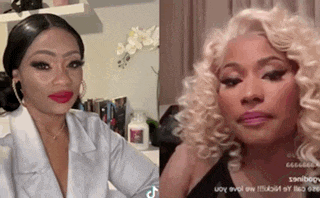 two women are standing next to each other in a room . one is wearing a white jacket and the other is wearing blonde hair .