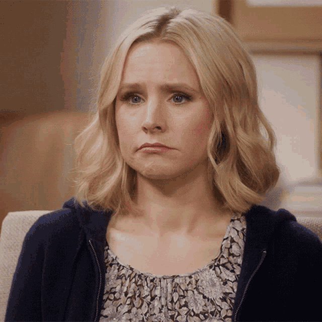 a woman with blonde hair and blue eyes is sitting in a chair