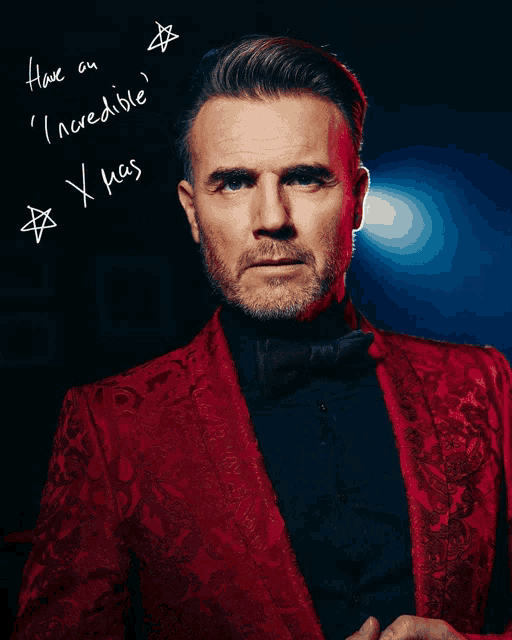 a man in a red tuxedo has a christmas message written on the back of his jacket