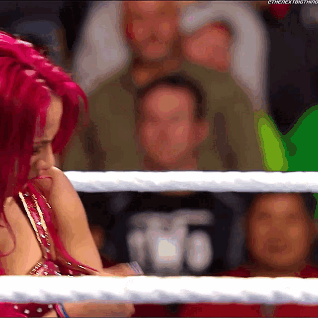 a woman with red hair is in a wrestling ring with the next thing written in the corner