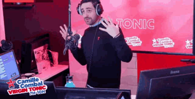 a man wearing headphones stands in front of a screen that says camille combat virgin tonic