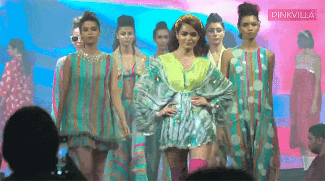 a group of models walk down a runway with a pinkvilla logo in the corner