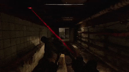 a video game is being played in a dark room with a red light coming out of the ceiling .