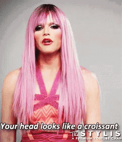 a woman with long pink hair is wearing a red dress and a pink wig .
