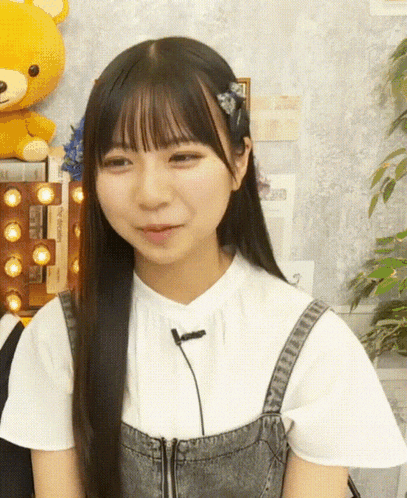 a girl wearing overalls and a white shirt with a microphone
