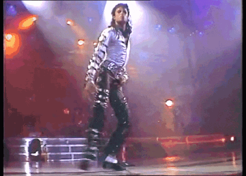 a man in a striped shirt is dancing on a stage