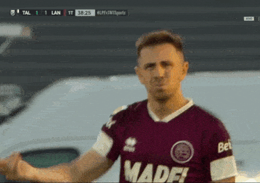 a soccer player wearing a maroon and white made jersey