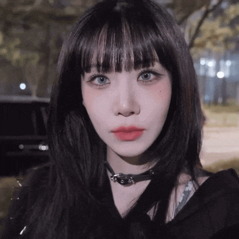 a close up of a woman wearing a choker and a black shirt