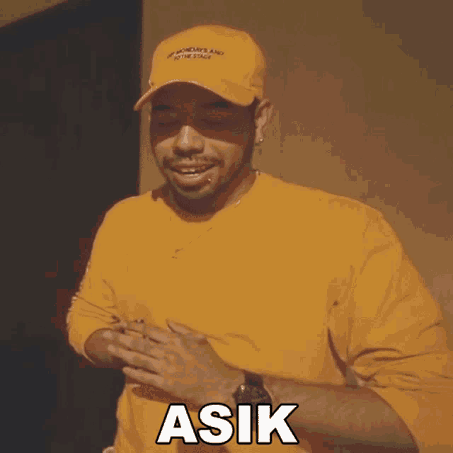 a man wearing a yellow shirt and a yellow hat has the word ask on his chest
