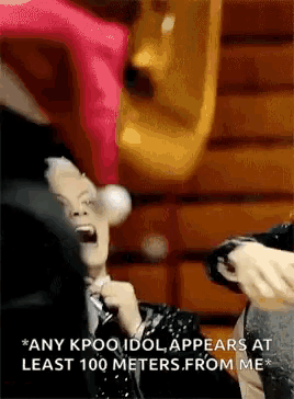 a person is screaming into a microphone while another person holds a balloon in their hand .