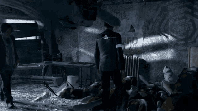 a man in a suit with a blue band around his wrist stands in a room