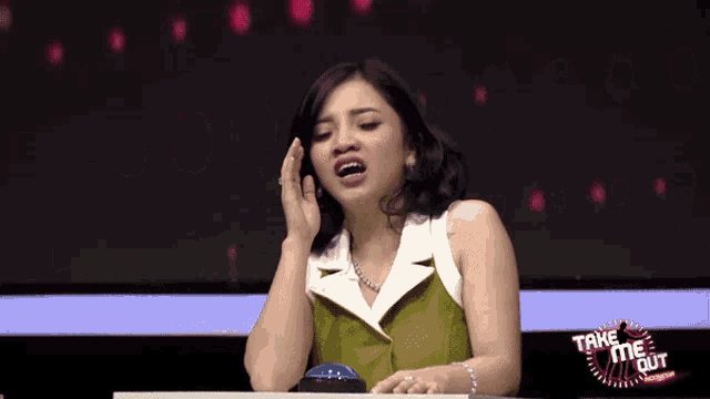 a woman sitting in front of a sign that says " take me out "