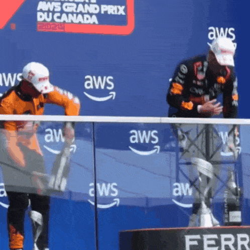two men standing on a podium at the aws grand prix in canada