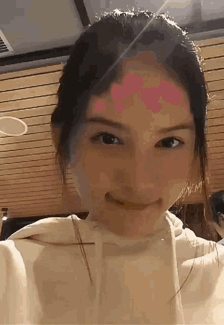 a close up of a woman 's face with a heart on her forehead