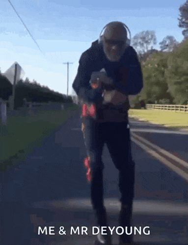 a man wearing headphones is walking down a road with the words me & mr deyoung written below him