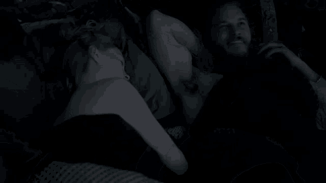 a man and a woman are laying on a bed together