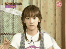a girl with pigtails is wearing a t-shirt that says ' a ' on it
