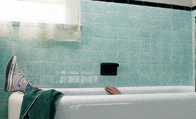 a person laying in a bathtub with their feet up