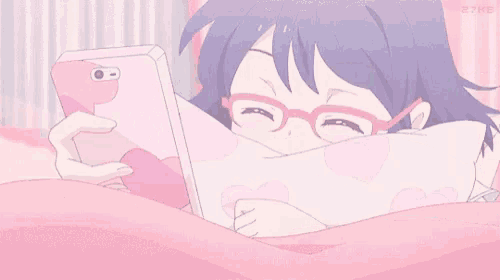 a girl wearing glasses is laying on a bed looking at her phone .