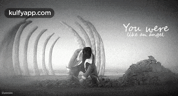 a black and white photo of a man kneeling down next to a pile of bones .