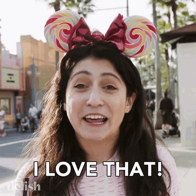 a woman wearing a lollipop ear headband says " i love that "