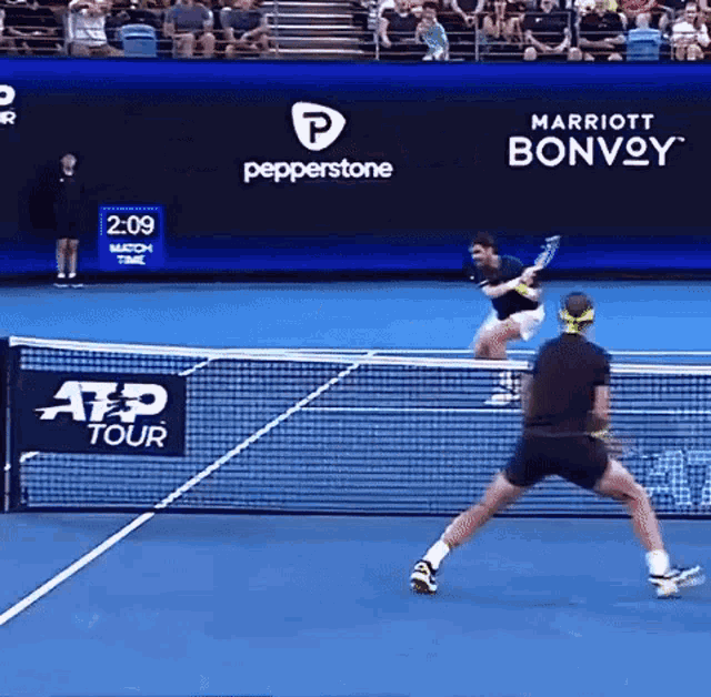 two men are playing tennis on a court sponsored by marriott