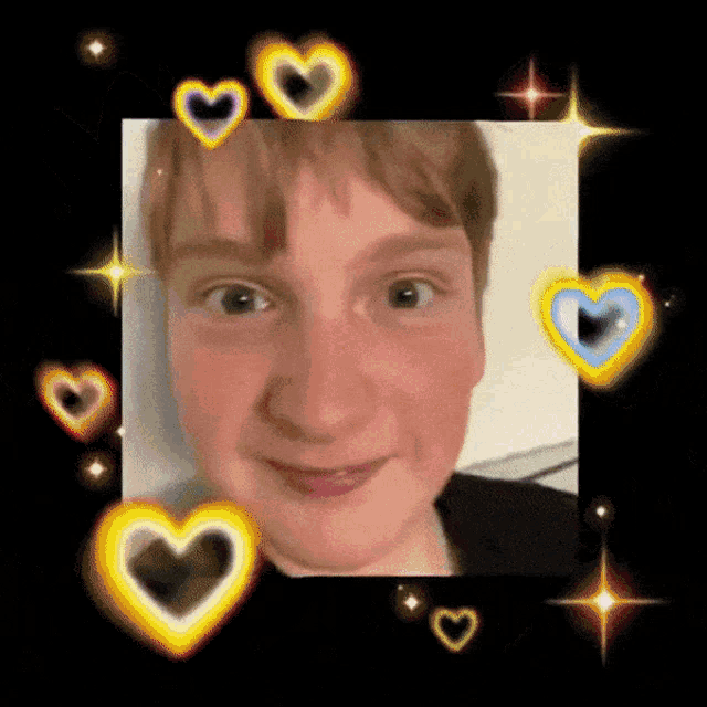 a man 's face is surrounded by hearts on a black background .