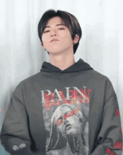 a young man wearing a hoodie with the word pain on it