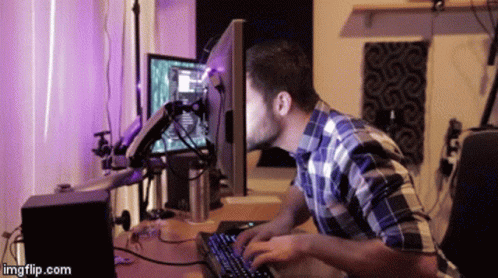 Homem com o rosto enfiado na tela de um computador.