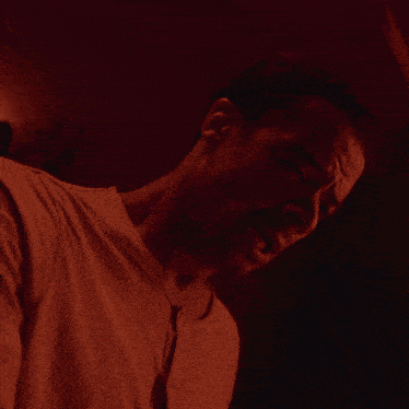 a close up of a man 's face in a dark room with his eyes closed