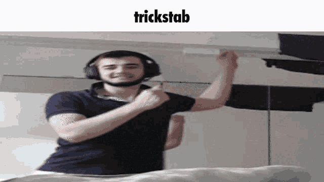 a man wearing headphones is dancing on a bed with the words trickstab above him