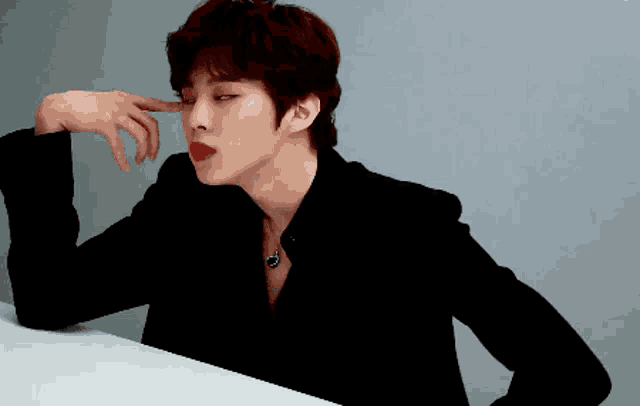 a man wearing a black jacket and red lipstick