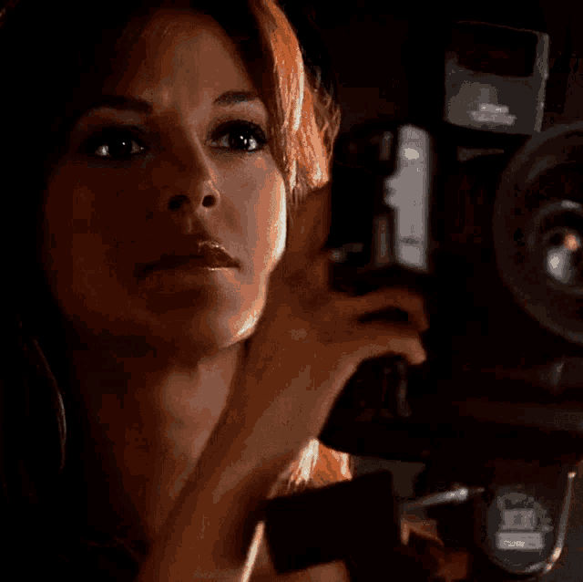 a close up of a woman holding a camera that says ' nikon ' on it