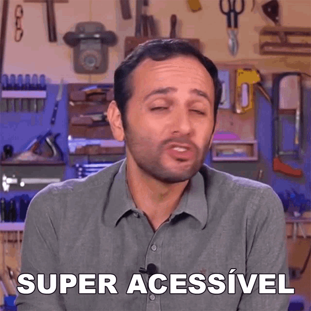 a man with his eyes closed says super acessivel in front of a wall of tools