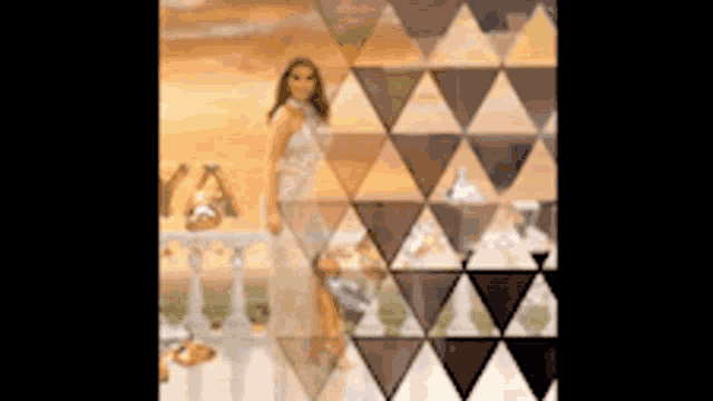 a blurry picture of a woman in a white dress standing in front of a triangle wall .