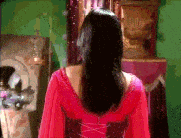 a woman in a red dress stands in front of a mirror