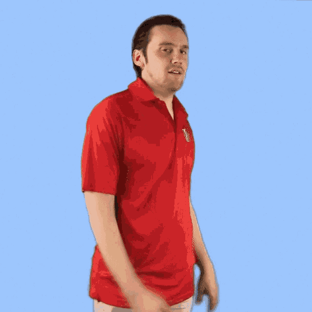 a man wearing a red polo shirt with the letter v on the pocket