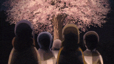 a group of people are looking at a tree with pink flowers