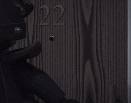 a lego man is standing in front of a door that has the number 22 on it
