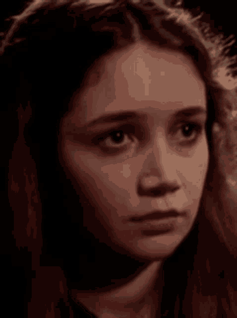 a close up of a girl 's face with a serious look on her face .